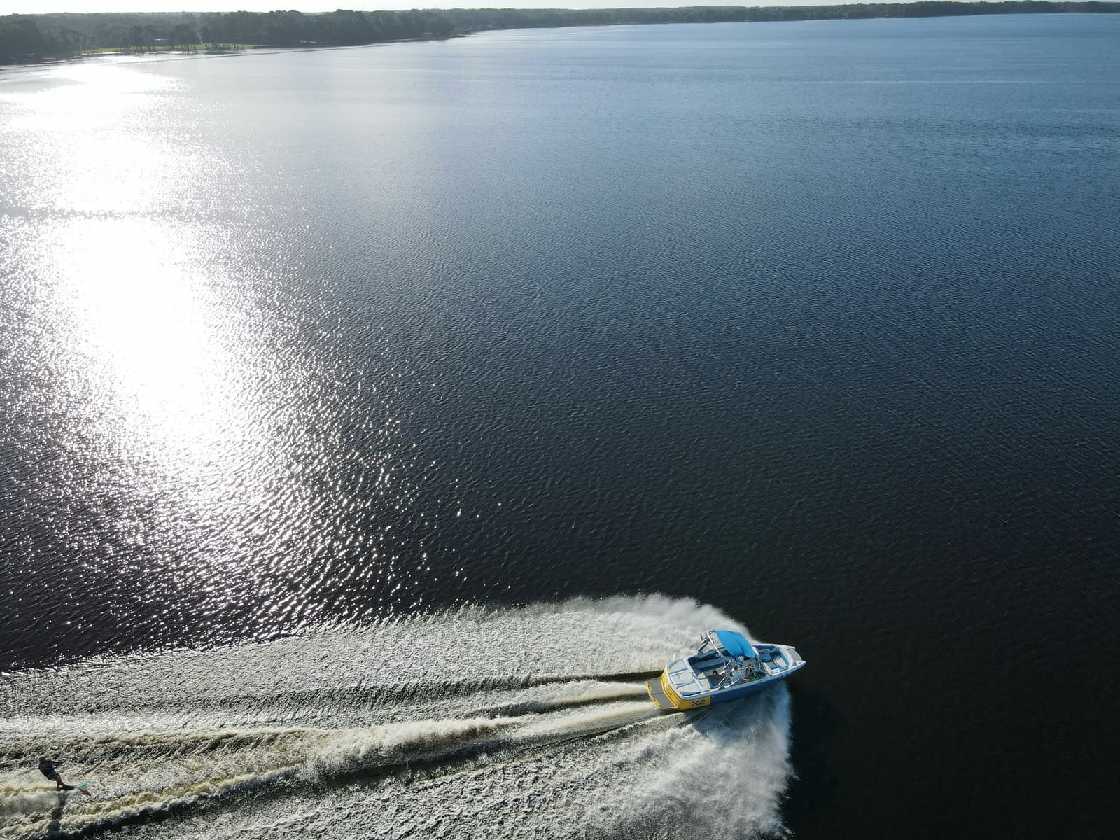 Aerial view of speedboat leaving a wake on calm dark water