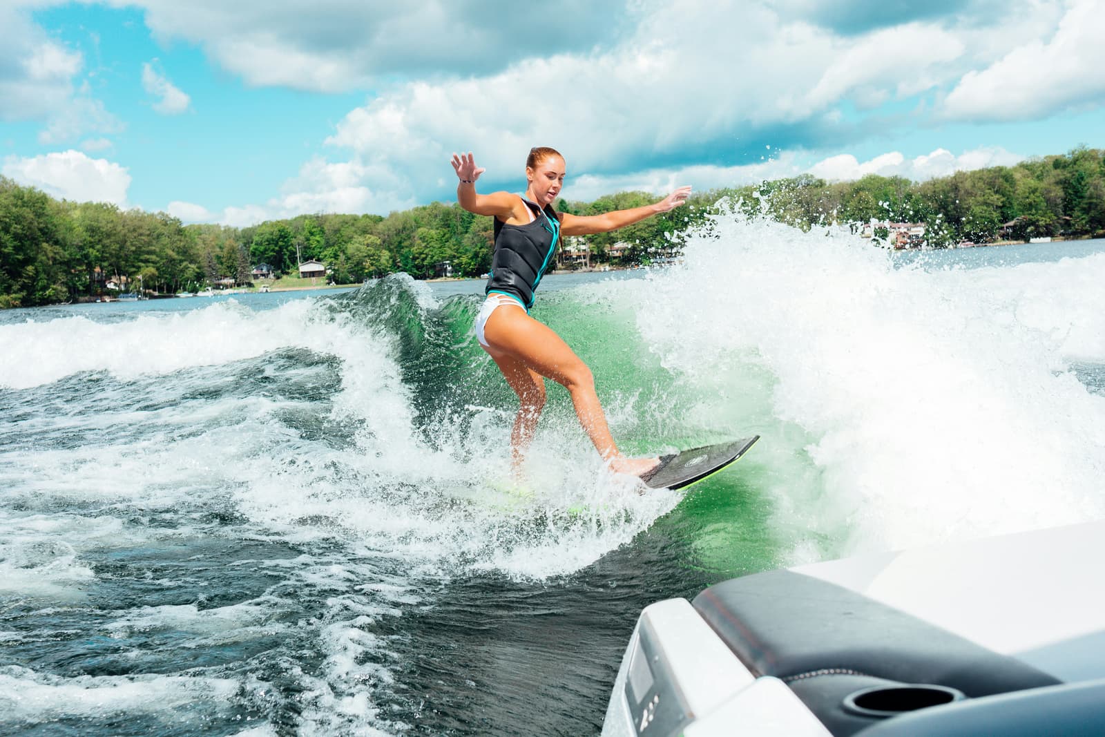 Woman wakesurfing behind a boat on a lake