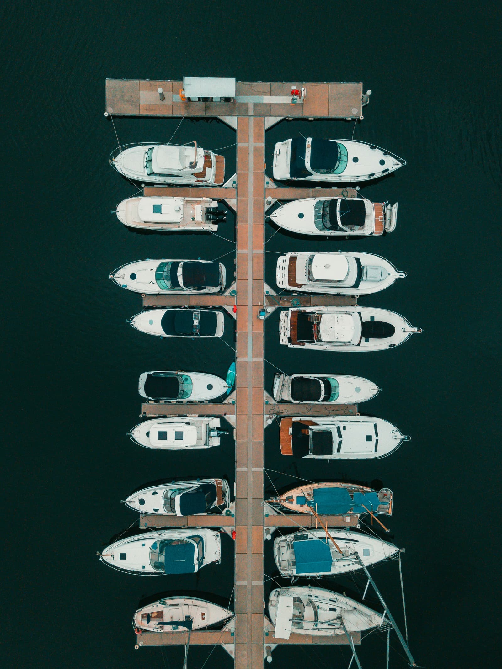 Aerial view of marina dock with boats moored on both sides
