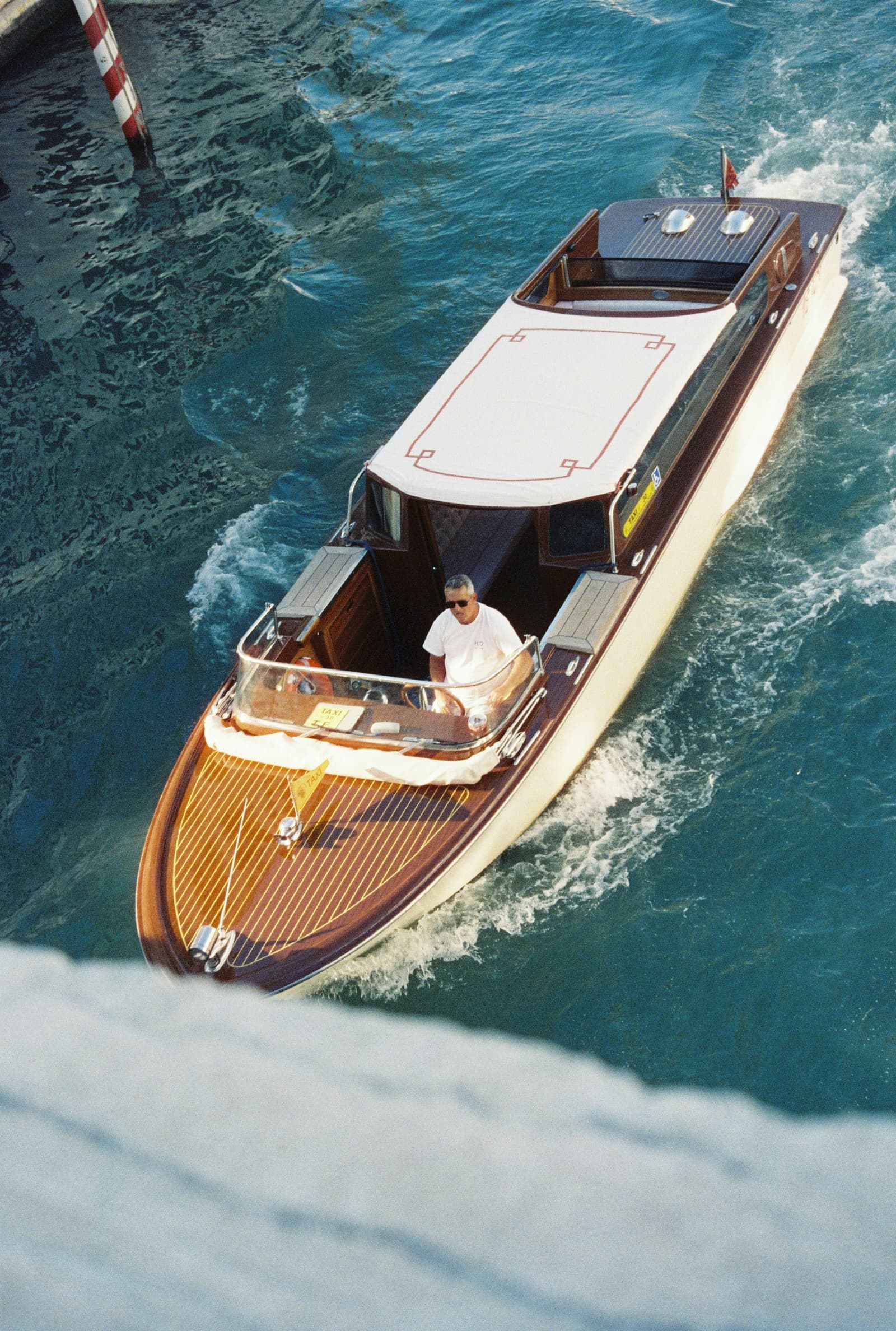 Classic wooden motor yacht cruising through turquoise water