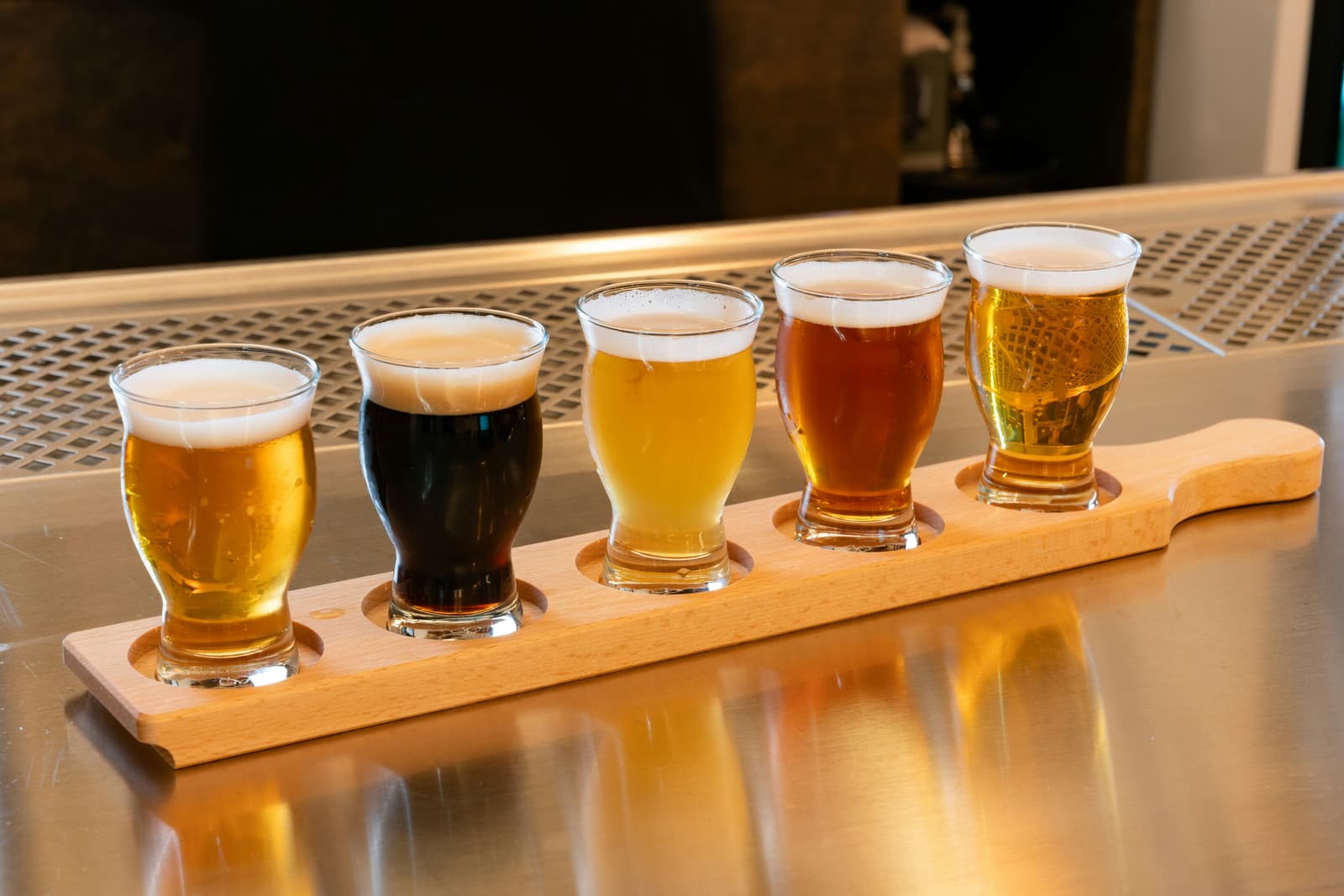 A flight of five craft beers on a wooden paddle at Trestle Brewing Co.