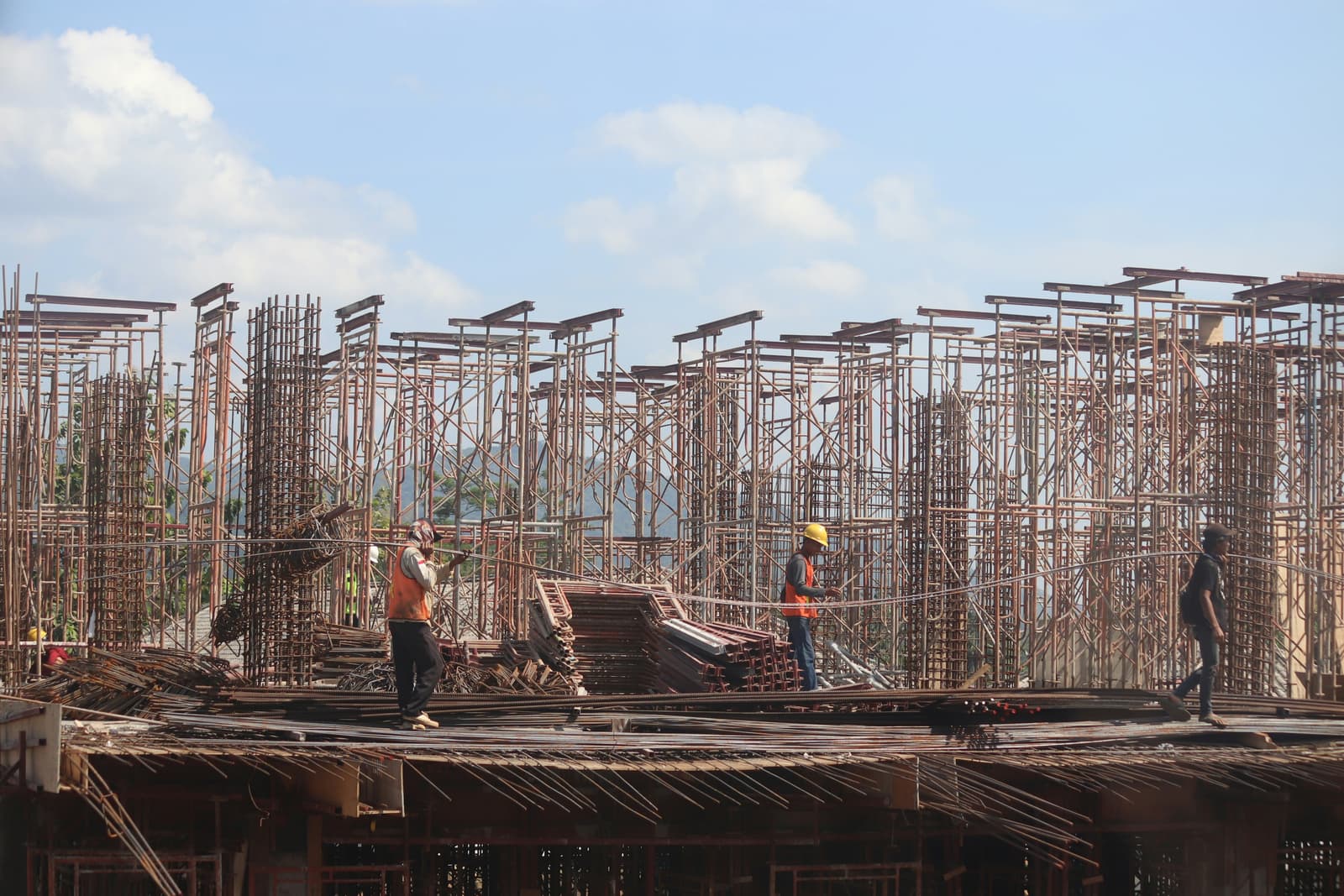 Workers on a large structural steel and scaffolding job site during building construction
