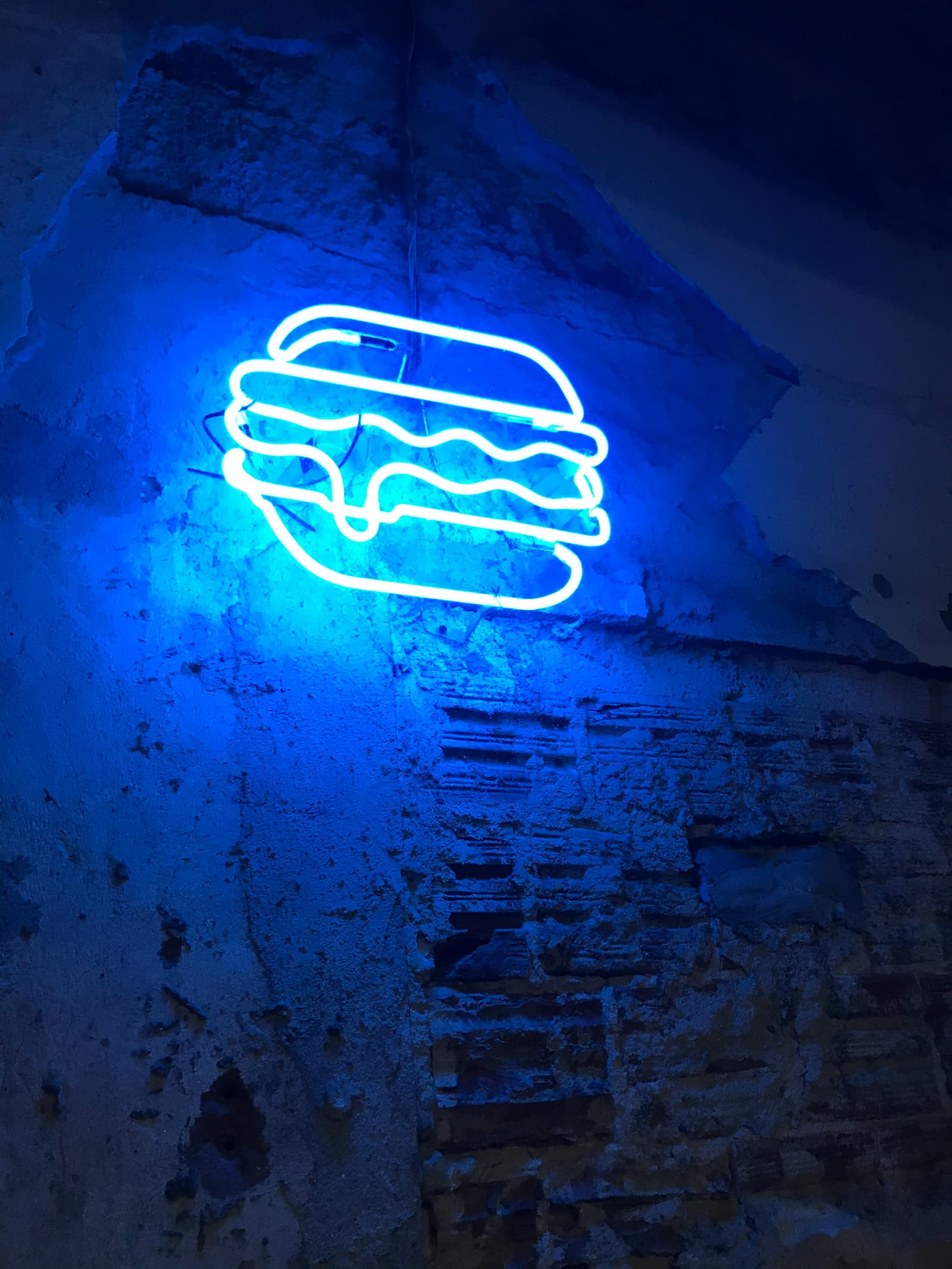 Neon burger sign on wall