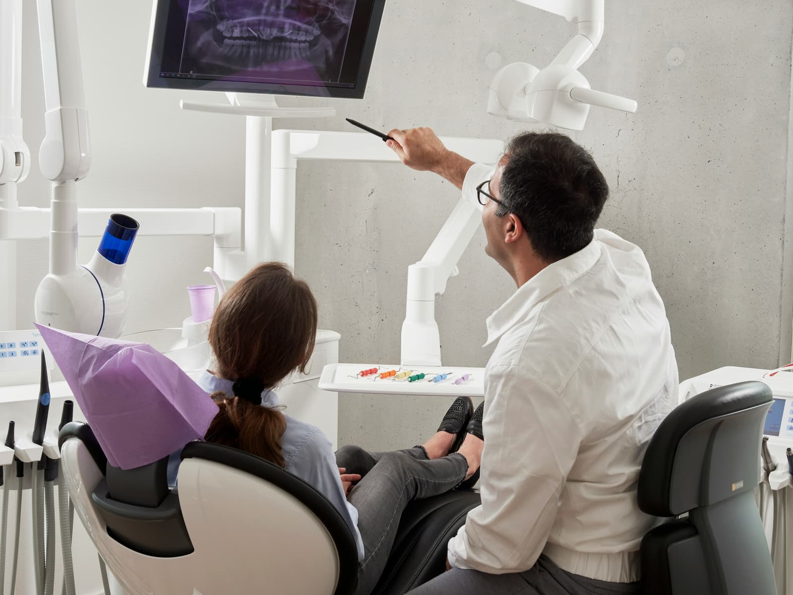 Dentist reviewing digital x-rays with patient on screen