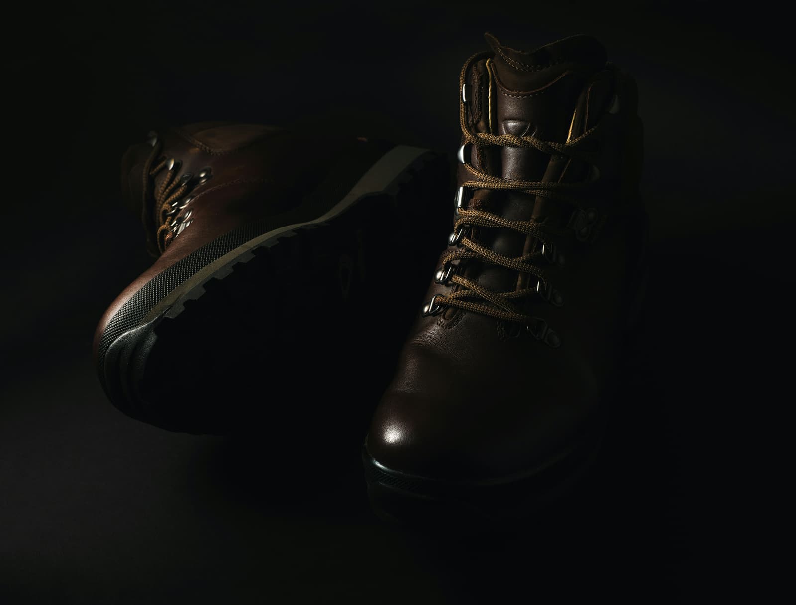 Pair of brown leather hiking boots on dark background